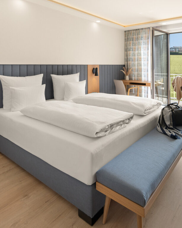 Stilvolles Schlafzimmer des Superior-Zimmers im Dreiflüssehof mit Zugang zum Balkon, der eine hervorragende Aussicht bietet.
