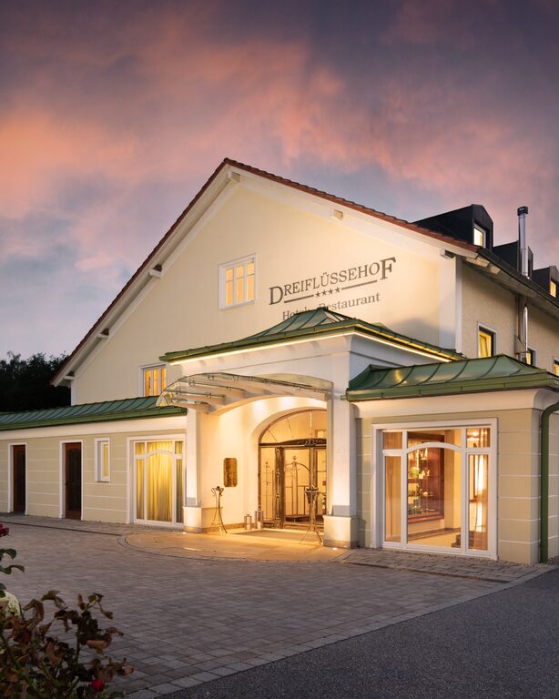 Die Eingangstür des charmanten Hotels Dreiflüssehof in Passau bei stimmungsvoller Nachtbeleuchtung.